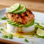 Plated Honey Lime Chicken & Avocado Rice Stack with cilantro garnish and lime sauce drizzle