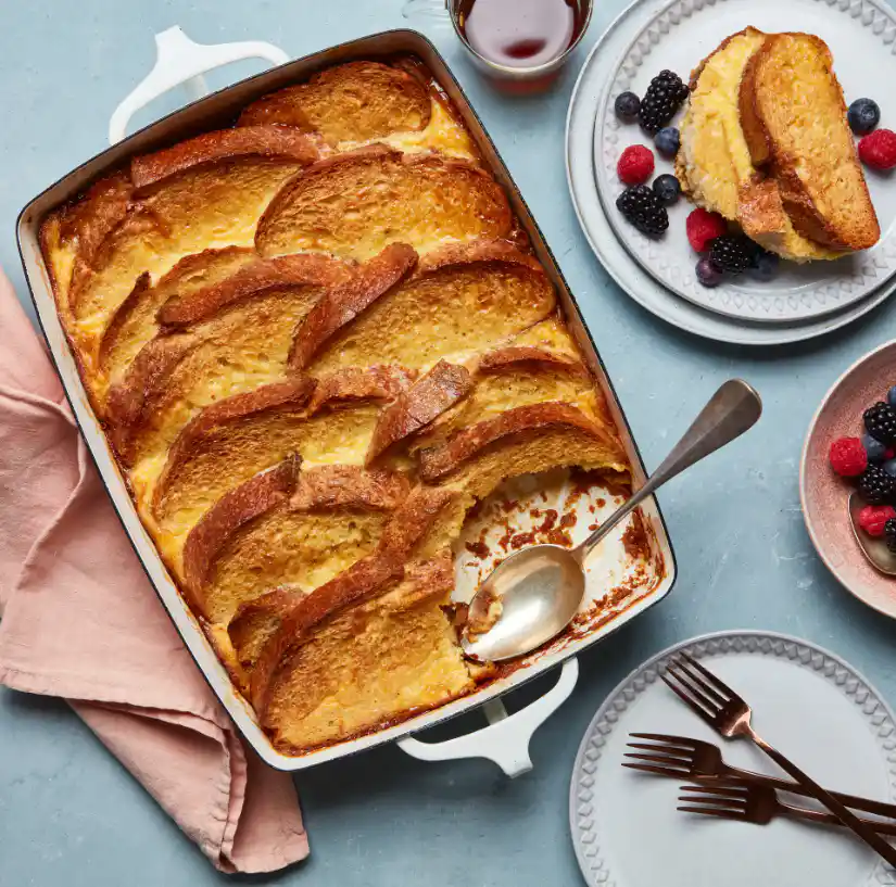 slice of creme brulee french toast casserole served with berries and syrup