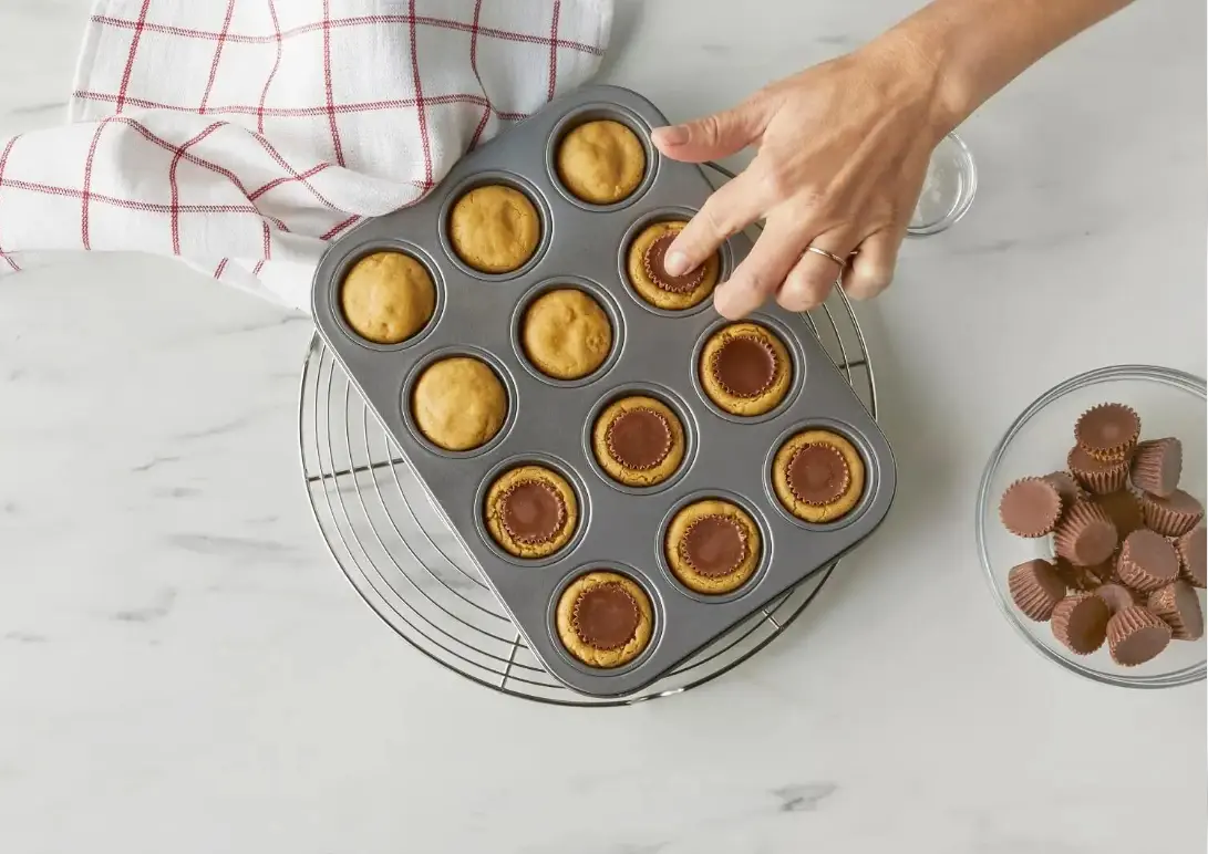 mini peanut butter cup being pressed into the center of a freshly